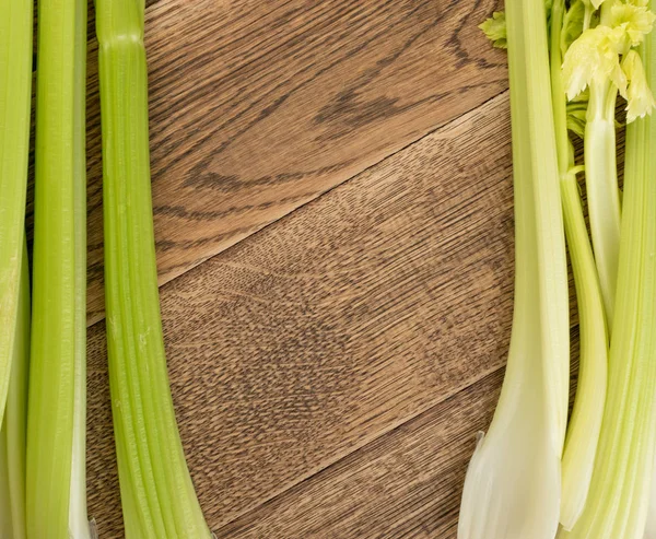 Ham yeşil kereviz ahşap arka plan üstten görünüm üzerinde takip ediyor. Eski ahşap rustik masa metin veya boşaltmak için yer ile taze organik sebze