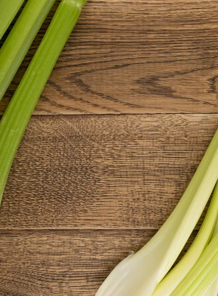 Ham yeşil kereviz ahşap arka plan üstten görünüm üzerinde takip ediyor. Eski ahşap rustik masa metin veya boşaltmak için yer ile taze organik sebze