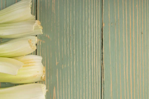 Ham yeşil kereviz ahşap arka plan üstten görünüm üzerinde takip ediyor. Eski ahşap rustik masa metin veya boşaltmak için yer ile taze organik sebze