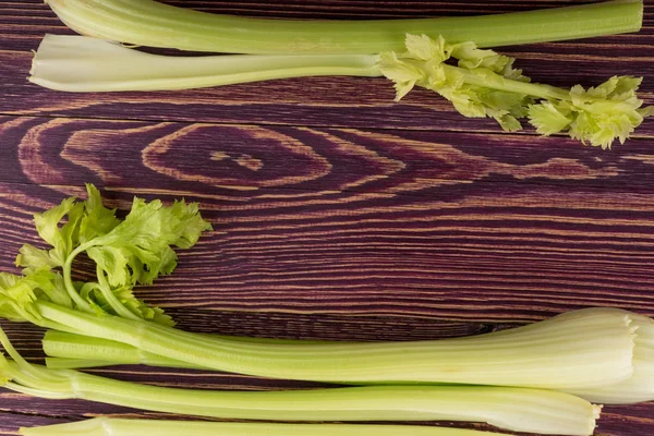 Ham yeşil kereviz ahşap arka plan üstten görünüm üzerinde takip ediyor. Eski ahşap rustik masa metin veya boşaltmak için yer ile taze organik sebze