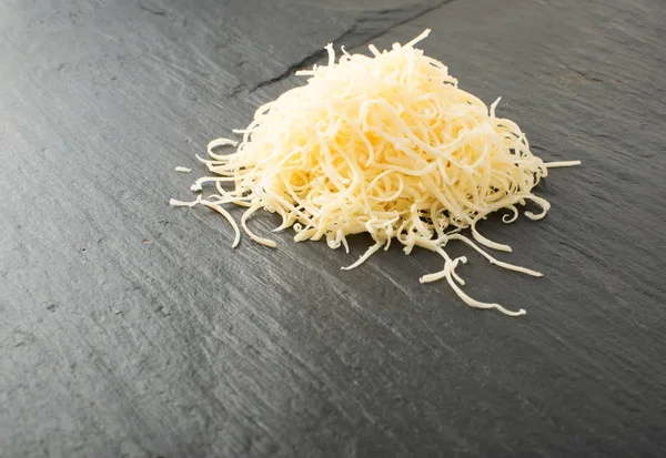 Siyah arka plan üzerine rendelenmiş peynir yığını. Yukarıdaki fotoğraf