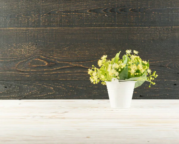 Ihlamur çiçek ahşap arka plan üzerinde. Güzel yaz buket ahşap masa doku üzerinde. Ihlamur çiçeği ile metin için yer