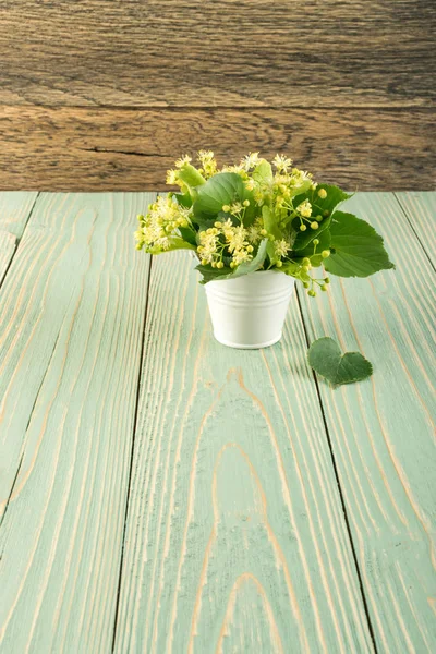 Ihlamur çiçek ahşap arka plan üzerinde. Güzel yaz buket ahşap masa doku üzerinde. Ihlamur çiçeği ile metin için yer