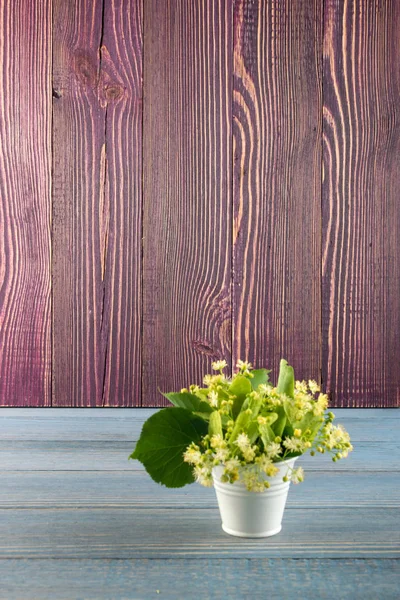 Ihlamur çiçek ahşap arka plan üzerinde. Güzel yaz buket ahşap masa doku üzerinde. Ihlamur çiçeği ile metin için yer