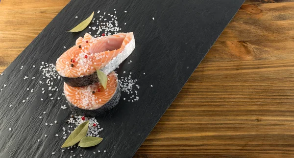 Doğal siyah arka plan üzerine çiğ somon Steak dilim. Taze kırmızı balık veya görünümünün alabalık en iyi yer ile metin için kalın parça