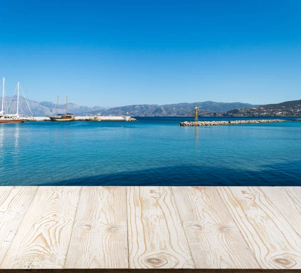 Güzel yaz günü manzaralı ahşap masa dışında. Rustik ahşap Resepsiyon deniz görünümü arka plan üzerine açık. Şablon ürün reklam için tezgah ile sahte