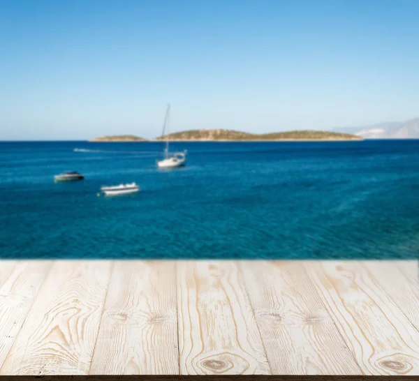 Güzel yaz günü manzaralı ahşap masa dışında. Rustik ahşap Resepsiyon deniz görünümü arka plan üzerine açık. Şablon ürün reklam için tezgah ile sahte