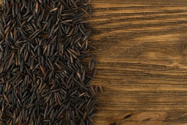 Raw Black Wild Rice Background Top View. Healthy Dietetic Canada Rice Cereal Texture with Place for Text