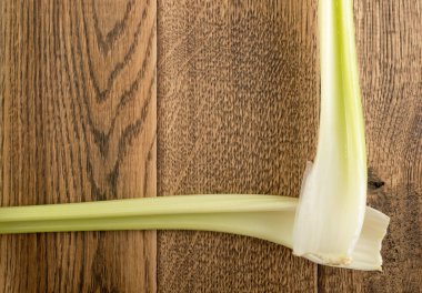 Ham yeşil kereviz ahşap arka plan üstten görünüm üzerinde takip ediyor. Eski ahşap rustik masa metin veya boşaltmak için yer ile taze organik sebze