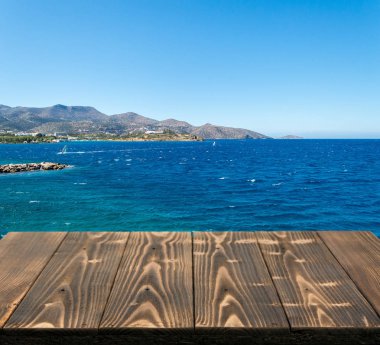 Güzel yaz günü manzaralı ahşap masa dışında. Rustik ahşap Resepsiyon deniz görünümü arka plan üzerine açık. Şablon ürün reklam için tezgah ile sahte