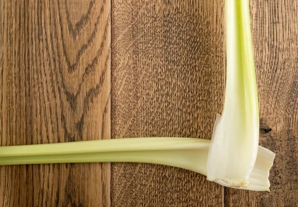 Ham yeşil kereviz ahşap arka plan üstten görünüm üzerinde takip ediyor. Eski ahşap rustik masa metin veya boşaltmak için yer ile taze organik sebze