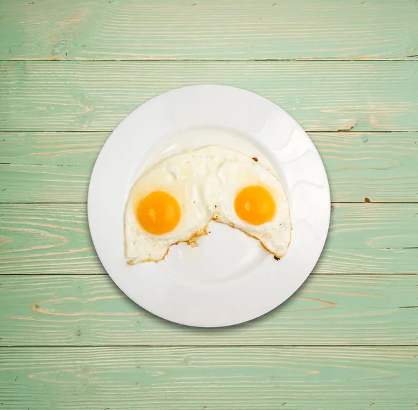 İki kızarmış yumurta beyaz ahşap Backgroynd üst görünüm üzerinde plaka ve yat