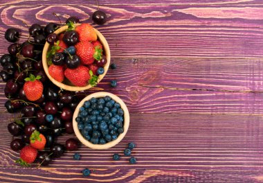 Taze kırmızı kiraz, böğürtlen ve çilek kopya alanı tasarım montaj veya mockup eski ahşap zemin üzerine. Rustik ahşap masa Danışma Kurulu doku tatlı çilek ile kadar yakın ve görünümü ana sayfa