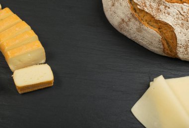 Peygamberli dilimlenmiş Limburger, Herve peynir veya Reblochon ve mavi Gorgonzola, rokfor veya Stilton. Peynir siyah sarı ve mavi peynir üstten görünüm karışımı ile ders taş plaka arka plan