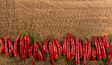 Çok sıcak biber rustik ahşap arka plan üstten görünüm üzerinde. Kırmızı baharatlı biber biber desen veya zemin için Hint menü için oryantal yiyecek tasarım