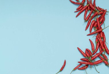 Çok sıcak biber mavi Kağıt arka plan üstten görünüm alanı olan metin için üzerinde. Kırmızı baharatlı biber biber desen veya zemin için Hint menü için oryantal yiyecek tasarım