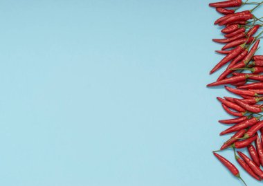Çok sıcak biber mavi Kağıt arka plan üstten görünüm alanı olan metin için üzerinde. Kırmızı baharatlı biber biber desen veya zemin için Hint menü için oryantal yiyecek tasarım