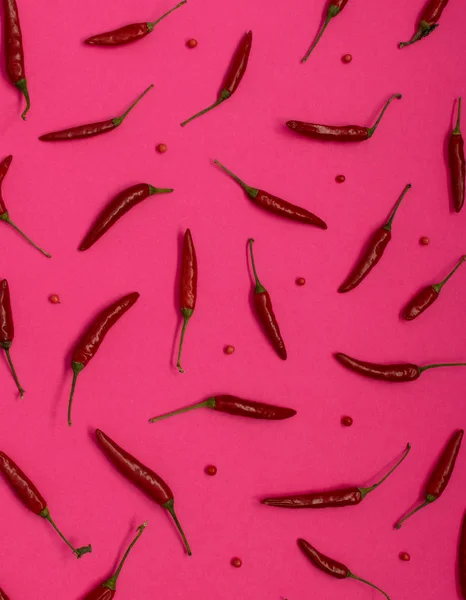 Very Hot Chili Peppers on Pink Paper Background Top View. Red Spicy Chilli Peppers Pattern or Backdrop for the Indian Menu for Oriental Food Design