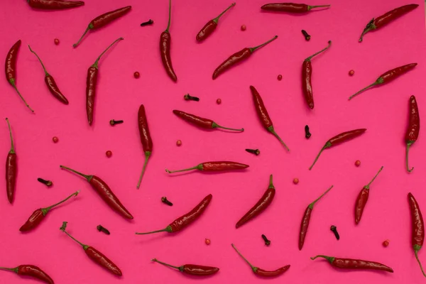Very Hot Chili Peppers on Pink Paper Background Top View. Red Spicy Chilli Peppers Pattern or Backdrop for the Indian Menu for Oriental Food Design