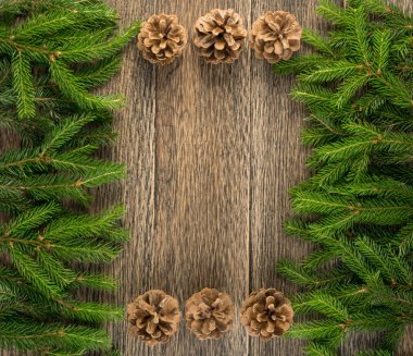 Noel çam dalları ve çam kozalakları ahşap zemin düz yatıyordu ve üst görünümünde arka plan. Noel Yortusu çerçeve çiçek dekorasyon kopya alanı ile. Yaratıcı xmas ağacı sınır için yeni yıl tebrik kartı