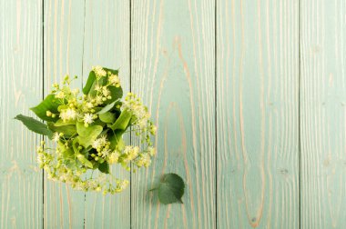 Ihlamur çiçek ahşap arka plan üzerinde. Güzel yaz buket ahşap masa doku üzerinde. Ihlamur çiçeği ile metin için yer