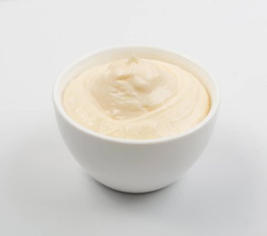 Ev yapımı zeytin mayonez ya da küçük beyaz kase mayonez sos kapatın. Yunan yoğurt, ekşi krema, peynir puding veya Aioli gri arka plan üzerinde izole makro fotoğraf