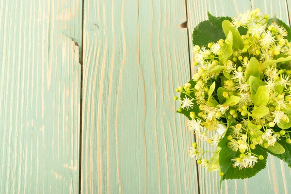 木製の背景にシナノキの花 木製のテーブルのテクスチャーに美しい夏の花束 テキスト シナノキの花 — ストック写真