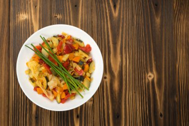 Kızarmış sebze karışımı kabak, tatlı biber, domates, soğan ile kapatın. Vejetaryen restoran servis tabağı doğranmış pişmiş sebze ve Yeşiller