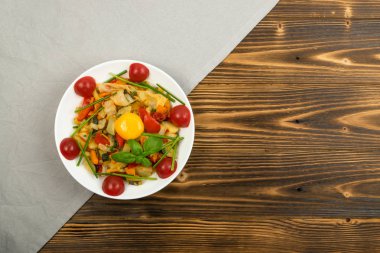 Kızarmış sebze karışımı kabak, tatlı biber, domates, soğan ile kapatın. Doğranmış pişmiş sebze ve Yeşiller boşaltmak rustik ahşap zemin üzerine Restoran Servis vejetaryen tabağı