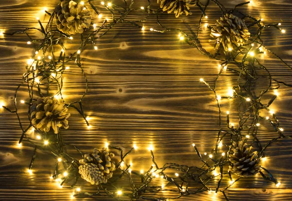 Christmas Light on Wooden Background Top View with Copyspace. Garland Lights on Vintage Wood Texture for New Year Frame or Xmas Mockup