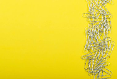 Not ataç sarı arka plan üstten görünüm üzerinde yığını. Çelik klipleri veya ataç ile boşaltmak yığını