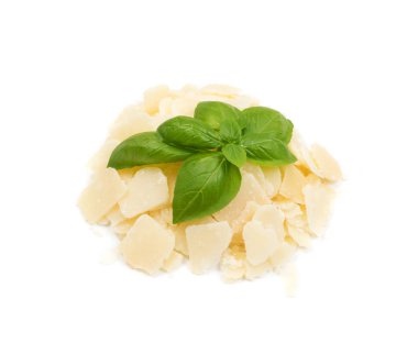 Parmesan peynir pul ve kırıntıları beyaz arka plan üzerinde izole fesleğen yaprakları ile yığını. İtalyan kahvaltilari reggiano salata ve makarna için kare parçaları yakın çekim