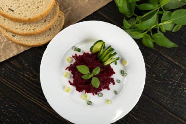 Zarif ahşap rustik arka plan üzerinde beyaz Restoran tabak rendelenmiş turşusu pancar kökü hizmet kapatın. Ev yapımı Marine pancar ekşi ve tatlı salamura içinde makro fotoğraf