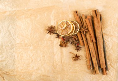 Kuru baharatlar ile susuz mulled şarap için vintage kraft paket Kağıt arka plan üzerinde narenciye dilimlenmiş. Kış oryantal baharat kurutulmuş lemon, karanfil, tarçın ve anason yıldız gibi görünümü top