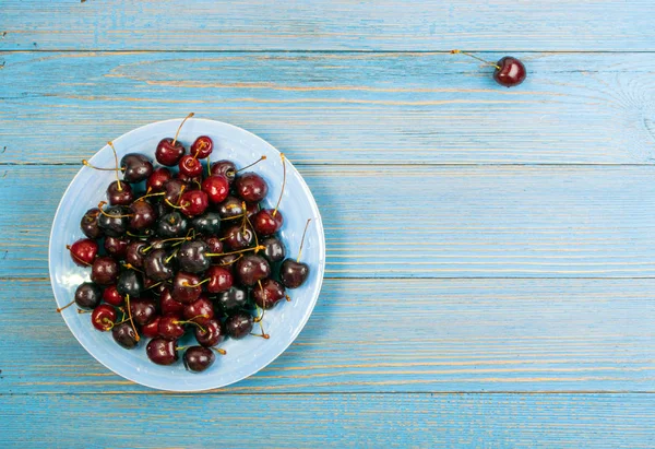 Plate Fresh Ripe Cherries Old Wooden Background Design Montage Blue — Stock Photo, Image