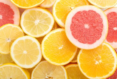 Doku, limon, portakal ve kırmızı greyfurt düz lay ve en iyi görünümü dilimlenmiş. Arka plan ile çok renkli meyveler