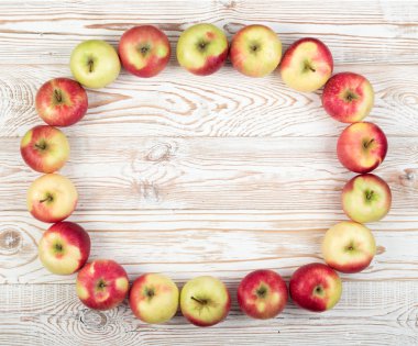 Bütün kırmızı ve yeşil yumuşak Apple desen üstten görünüm yer ile metin için. Yuvarlak meyve çerçeve veya ahşap rustik arka plan üzerinde organik elma ile sınır