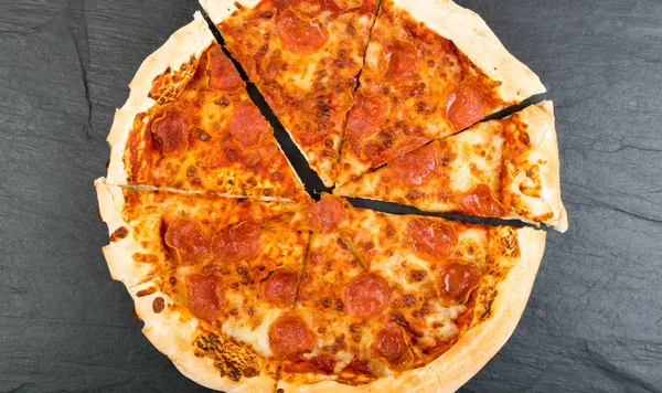 ペパロニや Diabola 黒い背景にサラミ 唐辛子 モッツァレラ チーズ チェリー トマト トマトソースのピッツァをクローズ アップ — ストック写真