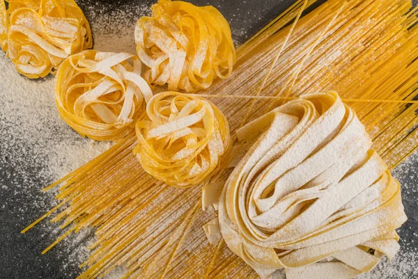 Macarrão italiano amarelo cru pappardelle, fettuccine ou tagliatelle — Fotografia de Stock