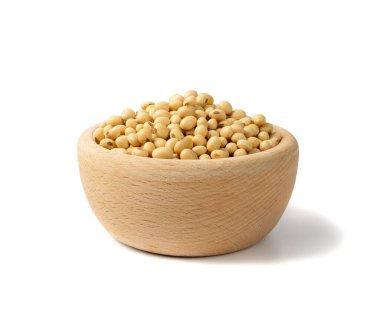 Beyaz arka planda çiğ susuz soya fasulyesi. Tahta kasede kuru soya fasulyesi, yakın plan soya fasulyesi yığını.