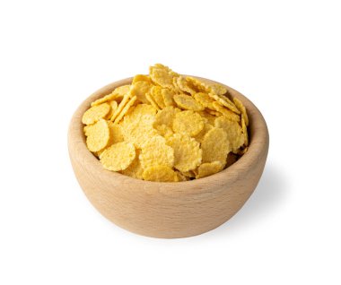 Kahvaltı için sarı mısır gevreği beyaz arka planda izole edilmiş yuvarlak ahşap kasede. Çıtır mısır gevreği, mısır gevreği ya da mısır gevreği yığını.