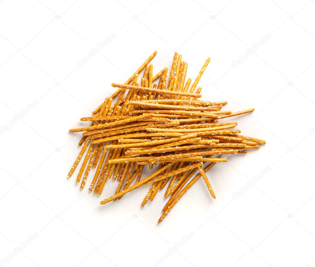 Pile of crispy salt sticks with white sesame isolated. Salty pretzel sticks, grissini or thin breadsticks top view