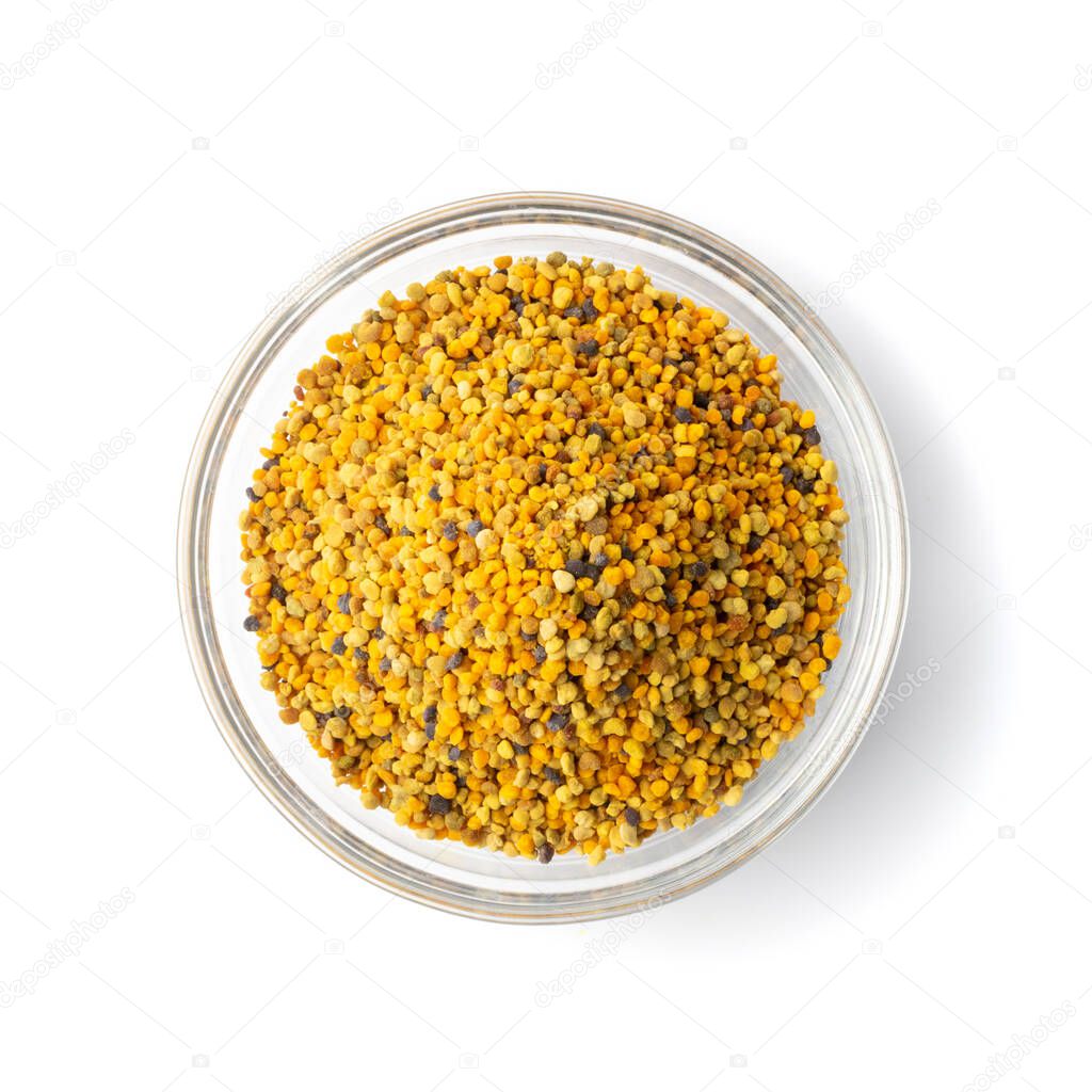 Pile of bee pollen or perga in glass bowl isolated on white background top view. Raw brown, yellow, orange and blue flower pollen grains or bee bread heap. Healthy food supplement