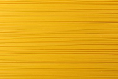 Çiğ sarı spagetti dokusu arka planda. Kuru yumurta, ev yapımı erişte, makarnalı duvar kağıdı ya da spagetti desenli makarna.