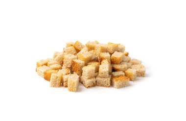 Pile of homemade bread croutons isolated on white background side view. Crispy bread cubes, dry rye crumbs, rusks, crouoton or white roasted crackers cube heap clipart