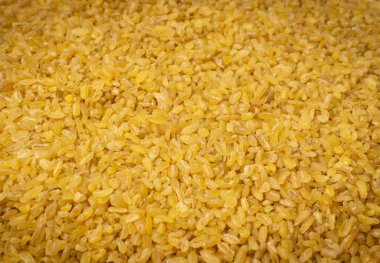 Bulgur taneciklerinin doku arka planı. Çiğ bulguru, kavrulmuş kavrulmuş buğday tohumu, mısır gevreği.