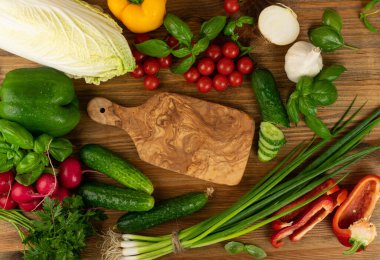 Odun kesme tahtası modeli. Yeşil sebzeli, yeşil sebzeli ve vişneli domatesli doğrama tahtası fotokopi odası manzaralı salata için hazır