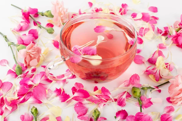 Karanfil yapraklı soğuk çiçek çayı. Yaz çiçekleriyle dolu cam bardakta gül suyu.