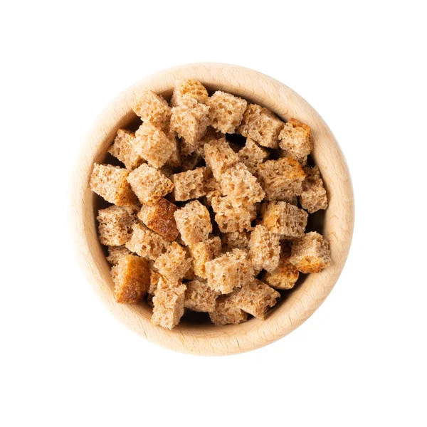 Pile of homemade rye bread croutons in wooden bowl isolated on white background top view. Crispy bread cubes, dry rye crumbs, rusks, crouoton or brown roasted crackers cube — Stock Image Pile Homemade Rye Bread Croutons Wooden Bowl Isolated White Background Stock Picture