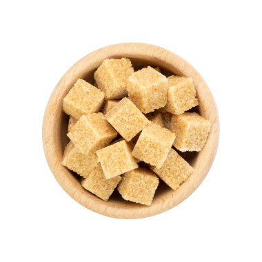 Beyaz zemin üzerinde izole şeker küpleri. Tahta kasede işlenmemiş kahverengi şeker, tatlandırıcı, glikoz üst görünüm.